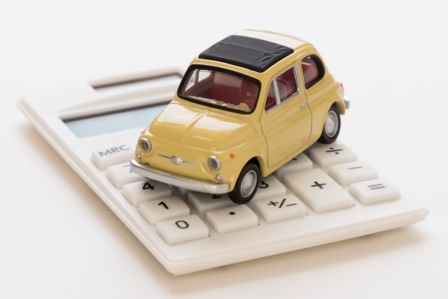電卓の上に乗る車の模型