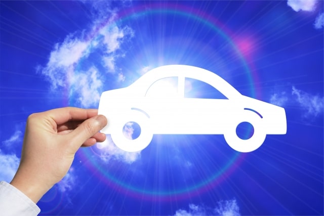 車のアイコンを片手で持つ人物